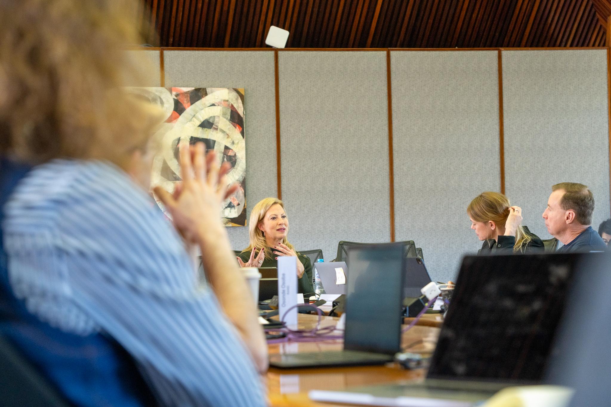 Corporate staff in discussion around a meeting table  