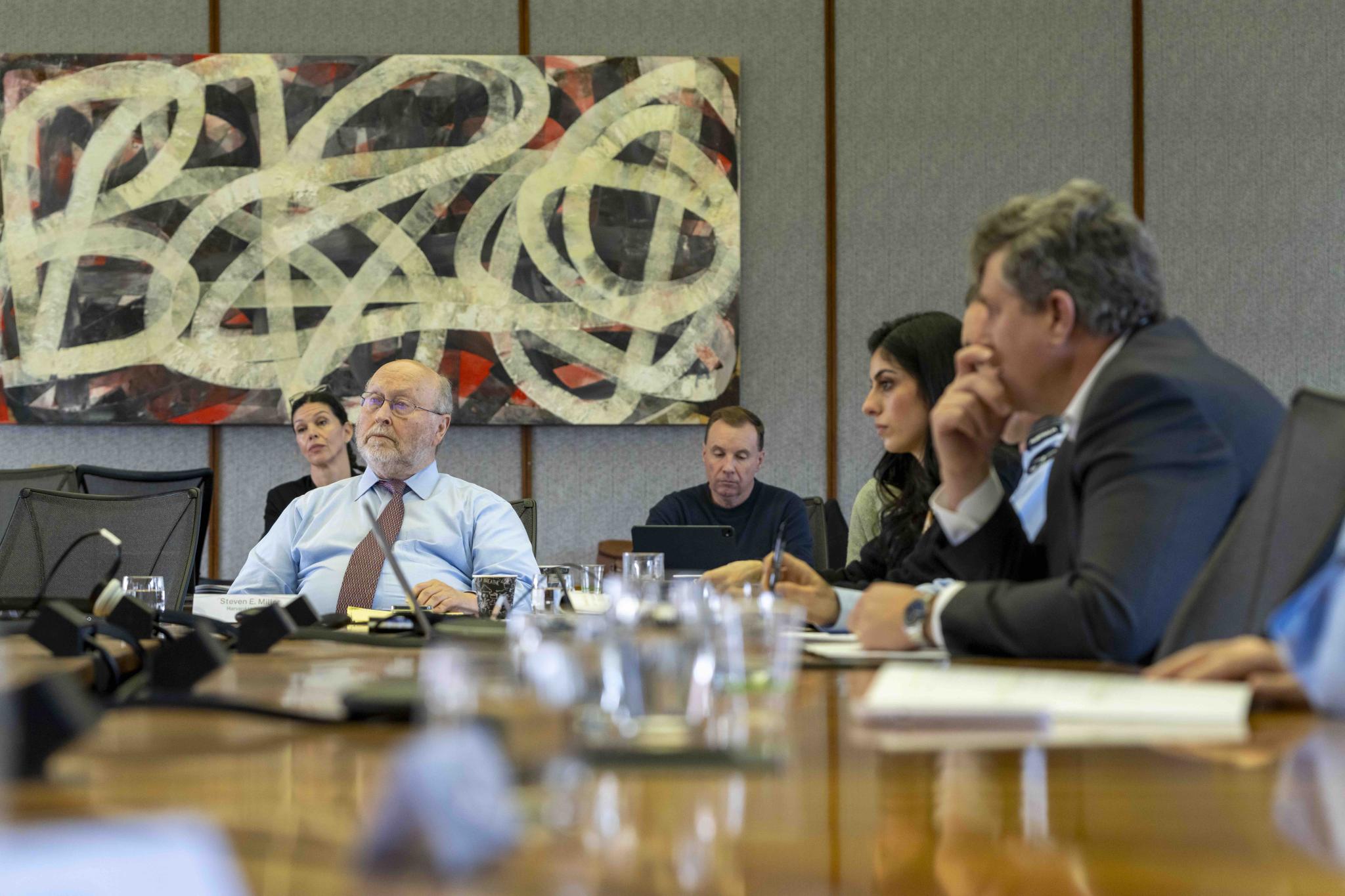 Corporate staff in discussion around a meeting table  