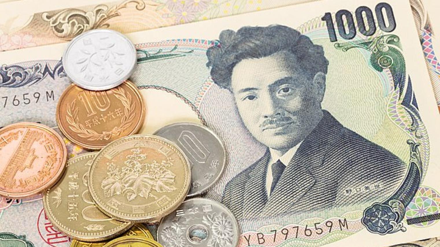 A collection of Japanese yen banknotes and coins. A 1,000 yen note featuring a portrait of Natsume Sōseki is prominently displayed, with various yen coins of different denominations, including 1, 5, 10, 50, 100, and 500 yen, scattered on top.